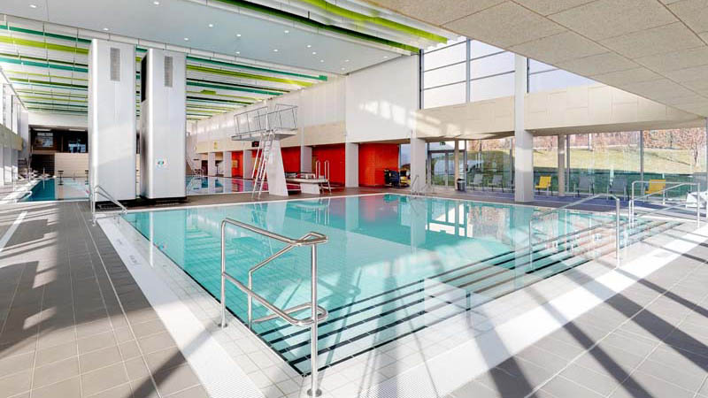 Sicht auf das Lehrschwimmbecken mit Tribüne und gezogener Schwimmbahn im Stadtbad Gotha