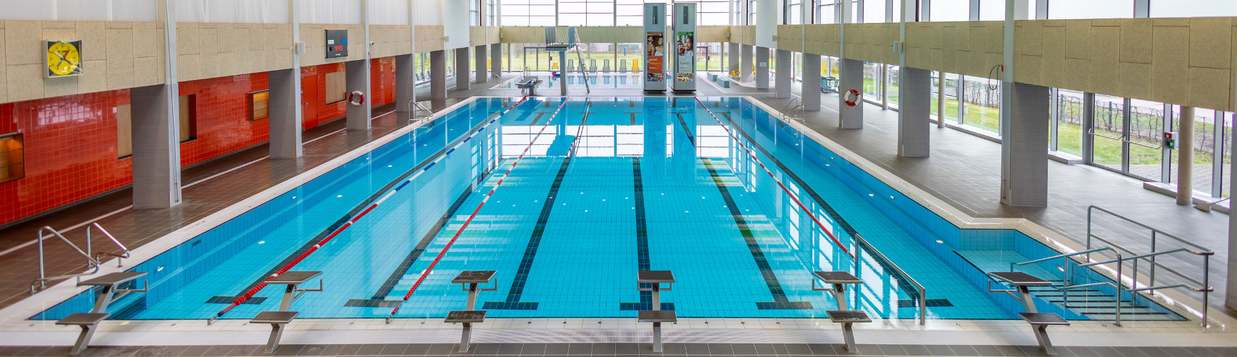 Sicht auf Lehrschwimmbecken mit Bahnen, im Hintergrund befindet sich die Tribüne im Stadtbad Gotha