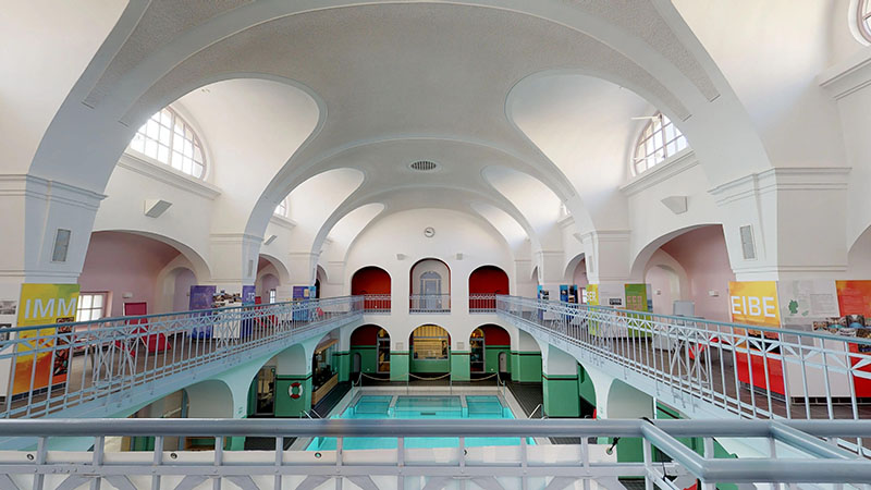 Sicht auf die kuppelförmige Decke im Stadtbad Gotha, rechts und links Bogendurchgängen im Stil der 20er Jahre.