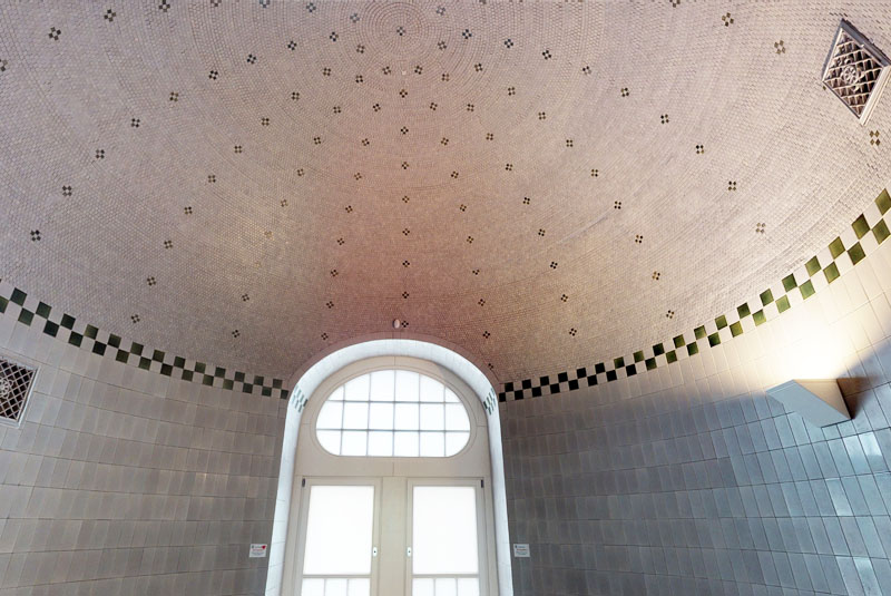 Sicht auf die Kuppeldecke aus Mosaiksteinchen und Zierrand, mit eingefasstem Holzfenster im Tepidarium Stadtbad Gotha